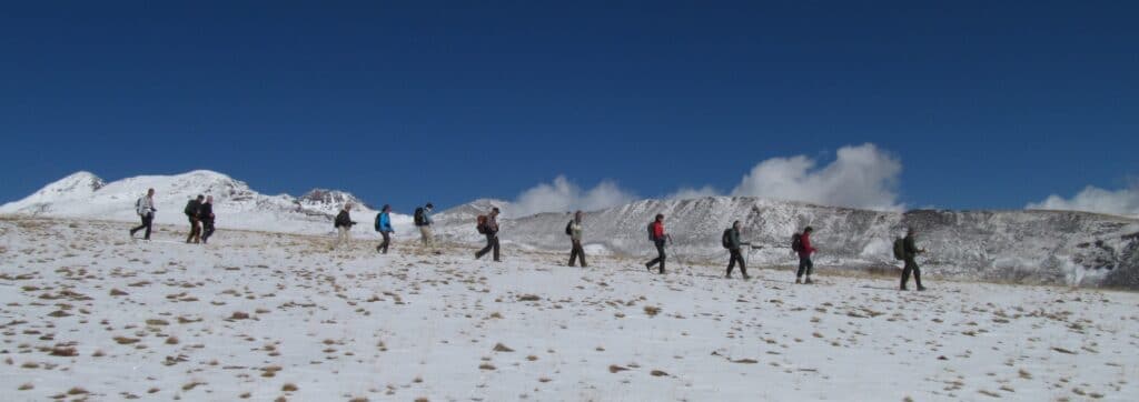 En bild på människor som vandrar på ett snöklätt berg
