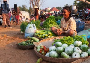En bild på en flicka som säljer grönsaker